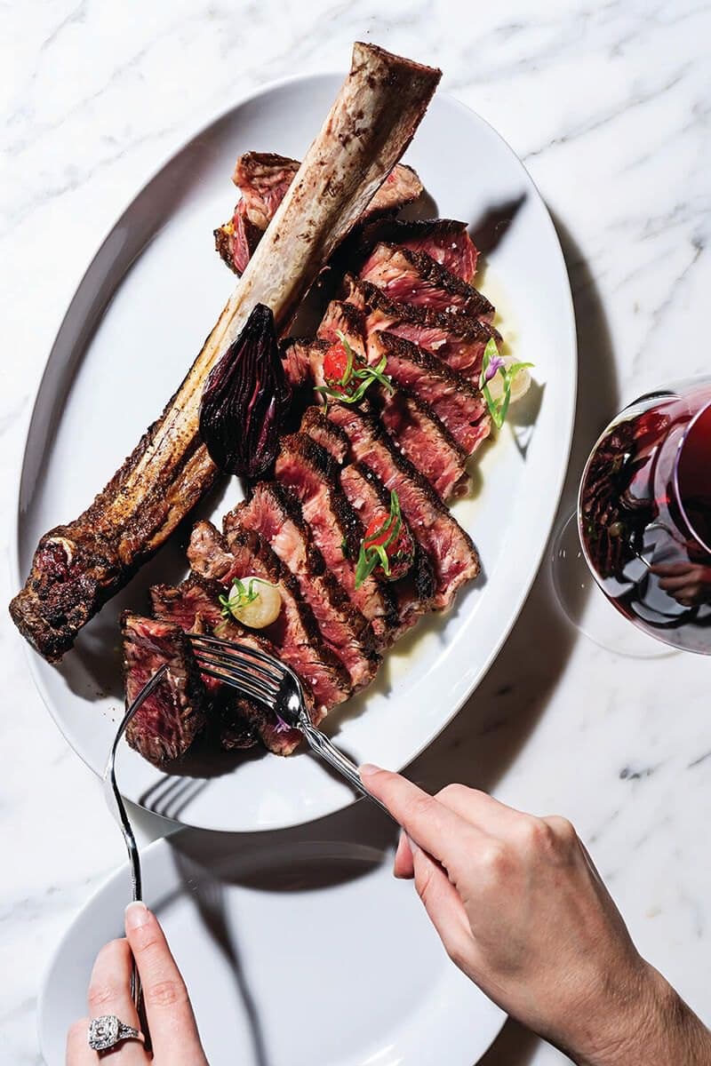 Tagliata di carne con osso su un piatto ovale