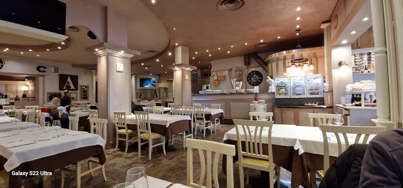 Sala interna del ristorante con i tavoli apparecchiati